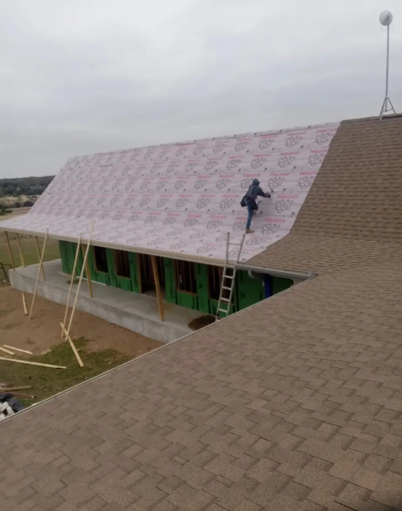 Worker preparing underlayment for a metal roof installation in Toccoa